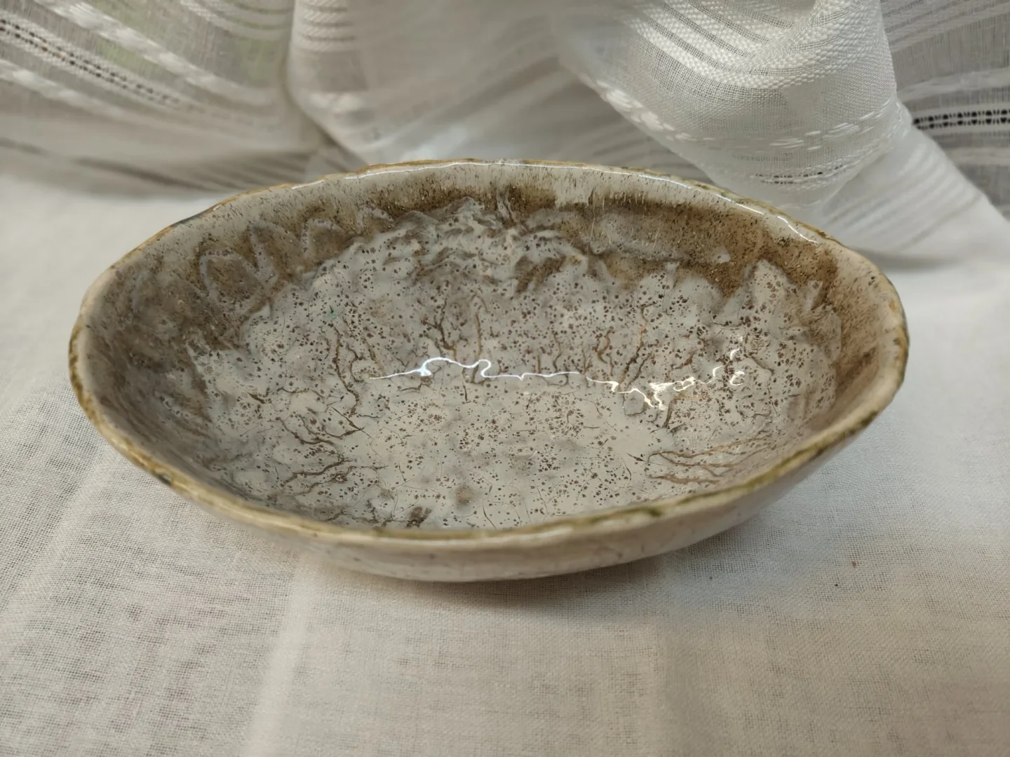 Płytka owalna misa ceramiczna w szarościach i brązach.